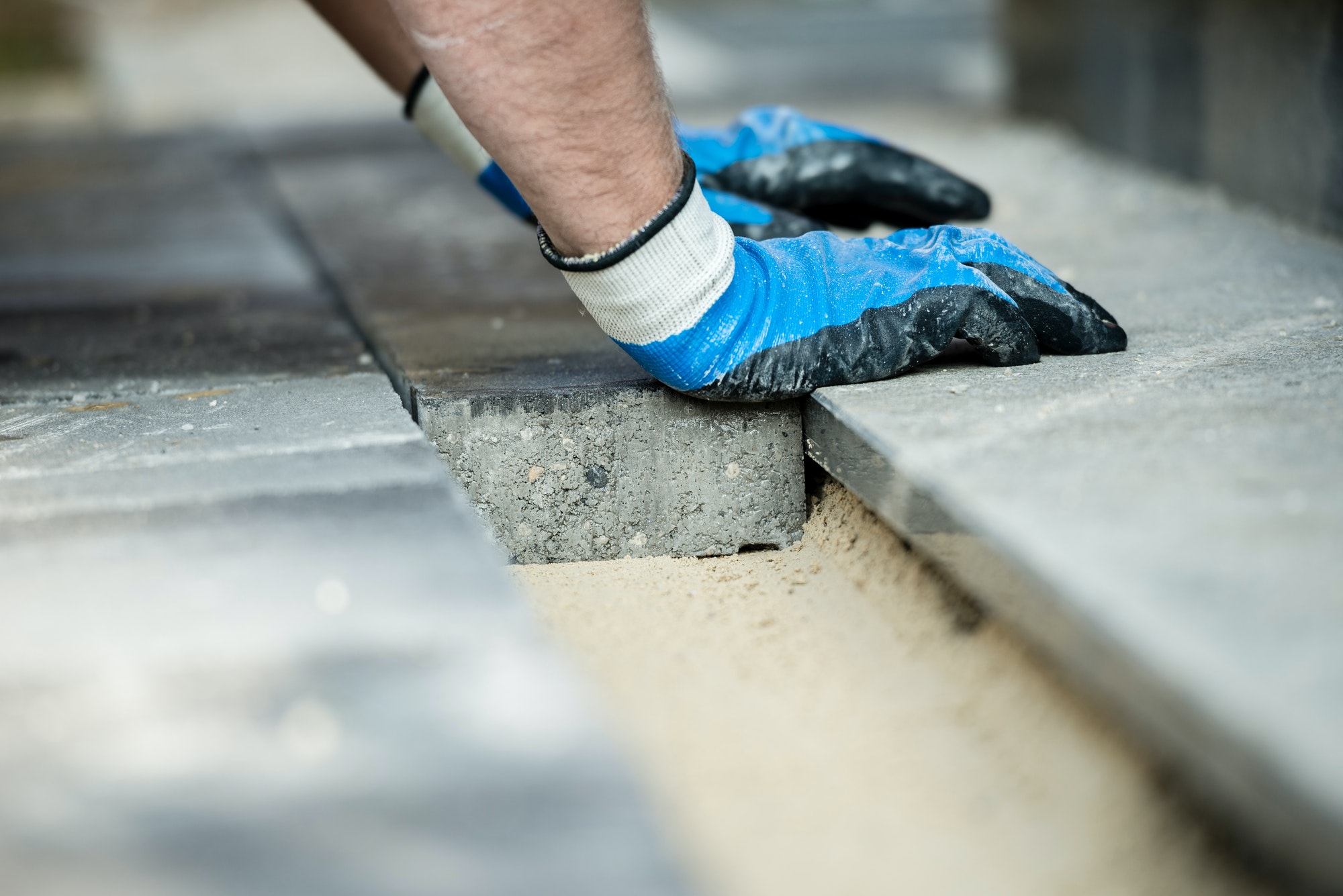 Builder laying new paving bricks